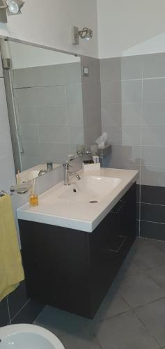 bagno con lavandino, specchio e servizi igienici di Battisti House a Besozzo