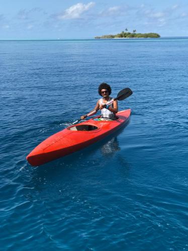 a person in a red kayak in the water at Summer Vibes Beach Front in Rasdu