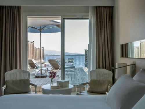 a hotel room with a bed and a view of a balcony at Sofitel Golfe d'Ajaccio Thalassa Sea & Spa in Ajaccio