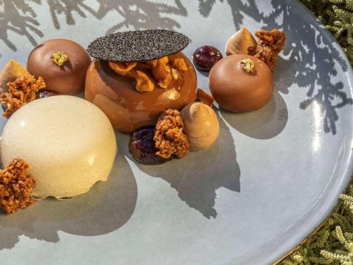 a plate of different types of donuts and nuts at Sofitel Golfe d'Ajaccio Thalassa Sea & Spa in Ajaccio
