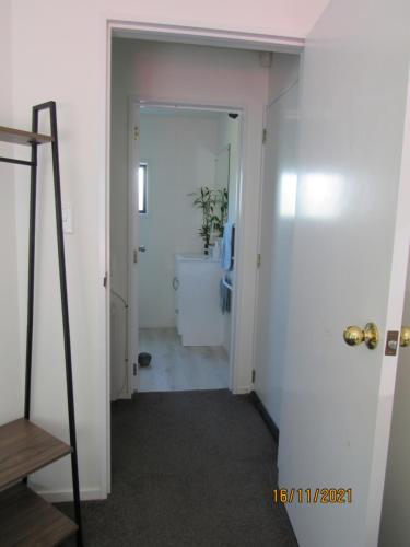 a hallway with a door leading to a bathroom at City Stay in Christchurch