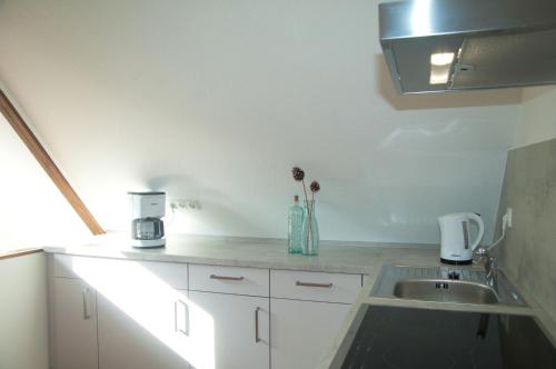 a kitchen with white cabinets and a sink at WG Bernstein - Reetdachhaus - Ruhe und Seeblick in Ostseebad Sellin