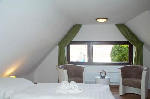 a attic bedroom with two beds and a window at Bernstein - Reetdachhaus - Ruhe - Seeblick in Ostseebad Sellin