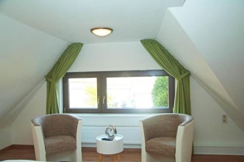 a attic room with two chairs and a window at WG Bernstein - Reetdachhaus - Ruhe und Seeblick in Ostseebad Sellin