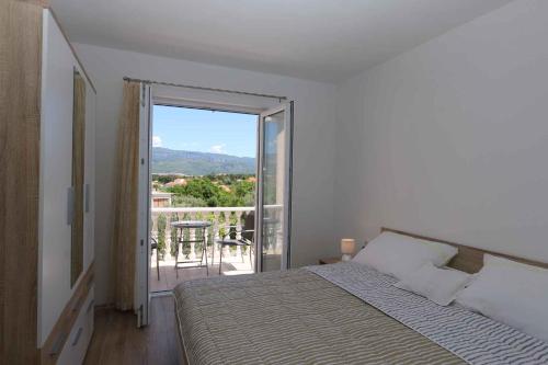 a bedroom with a bed and a view of a balcony at Apartment in Silo - Insel Krk 41833 in Šilo
