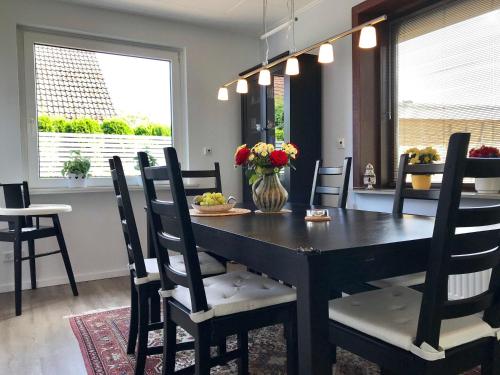 ein Esszimmer mit einem schwarzen Tisch und Stühlen in der Unterkunft Ferienhaus "Auf dem Bremsberg" in Glücksburg