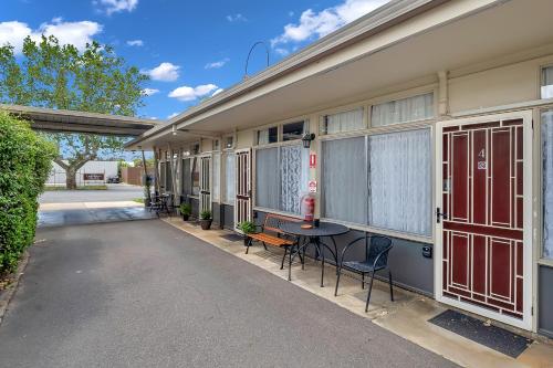 a side view of a building with a table and chairs at Central Wangaratta Motel in Wangaratta