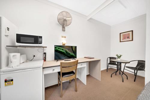 a room with a desk with a computer on it at Central Wangaratta Motel in Wangaratta