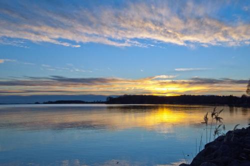 a sunset over a large body of water at WG Bernstein - Reetdachhaus - Ruhe und Seeblick in Ostseebad Sellin