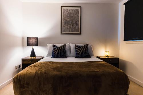 a bedroom with a large bed with two lamps at The Skyline Suite - *Private Balcony* *Views* in Glasgow