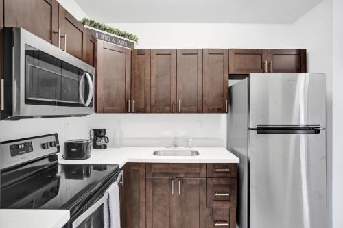 a kitchen with a white refrigerator and wooden cabinets at Renzzi Wynwood Apartments in Miami