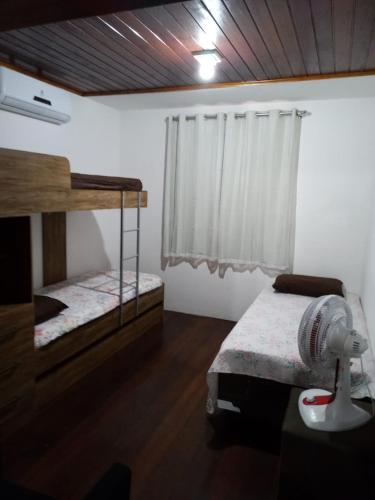 a bedroom with two bunk beds and a fan at SUPER DUPLEX - ALTO PADRAO - FRENTE PISCINAS E PARQUE INFANTIL- 02 VAGAS DE GARAGEM - Winterville - Gravatá HORÁRIO FLRXIVEL in Gravatá
