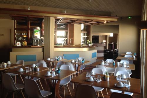 a restaurant with tables and chairs and a bar at Moka Hotel in Niort