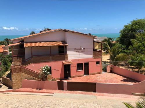a house on a hill with the ocean in the background at Bela Vista in Canoa Quebrada