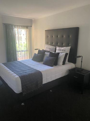 a bedroom with a large bed with pillows at Deco City Motor Lodge in Napier