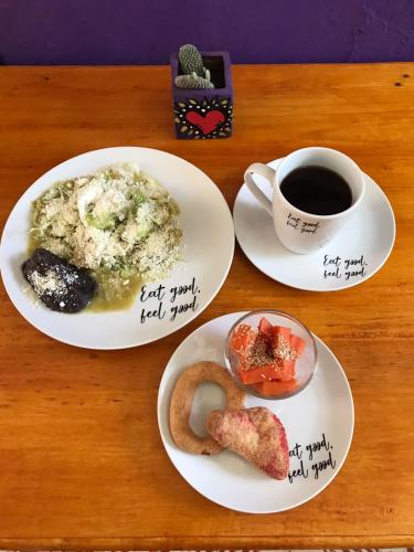 a table with two plates of food and a cup of coffee at Casa Apapacho hostel in San Cristóbal de Las Casas