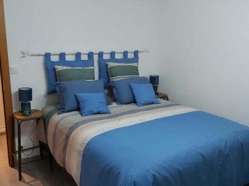 a blue bed with blue pillows on top of it at Gîte Gérardmer, 3 pièces, 4 personnes - FR-1-589-393 in Gérardmer