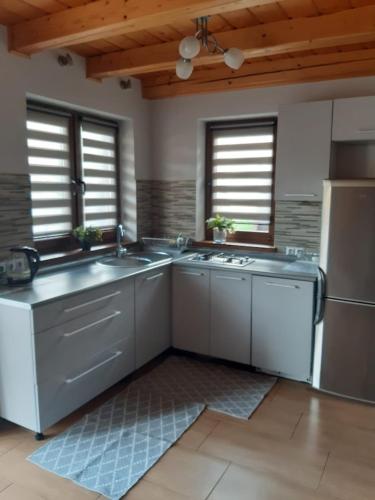 a kitchen with two sinks and a refrigerator at Domek w górach in Sucha Beskidzka