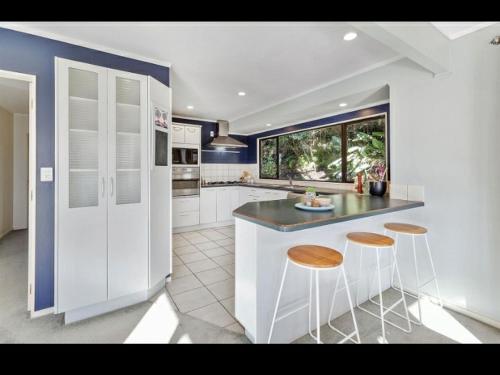 a kitchen with a counter and two stools in it at Lux. Room with Ensuite in Kelburn