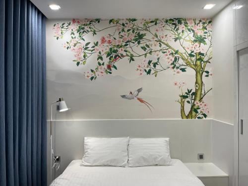 - une chambre avec une fresque murale sur les arbres dans l'établissement Gavi Home - Luxury Apartment Vinhome Green Bay Mễ Trì Hà Nội, à Hanoï