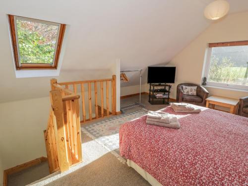 a bedroom with a bed and a tv in a room at Bryn Melyn Artist's Cottage in Llanelltyd