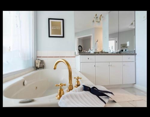 a white bathroom with a tub and a sink at Donna's Bed & Breakfast in White Rock