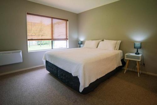 Un dormitorio con una cama grande y una ventana en Picton Country Hideaway, en Picton