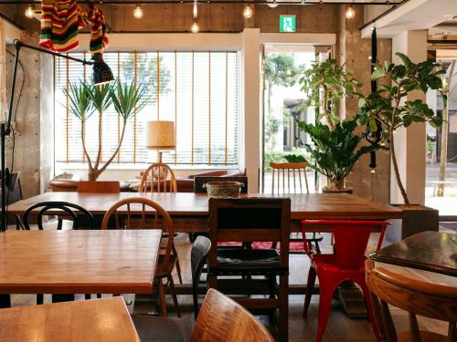 restauracja z drewnianymi stołami, krzesłami i oknami w obiekcie Hotel Toms w Tokio