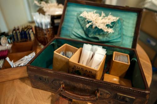 an open suitcase filled with books on a table at Hotel Toms in Tokyo