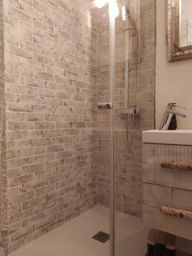 a bathroom with a shower with a brick wall at Iregua Playa in Laredo