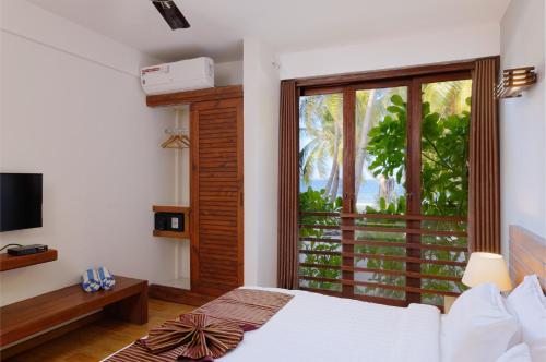 a bedroom with a bed and a large window at Aveyla Manta Village in Dharavandhoo