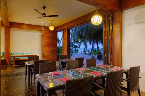 a dining room with a table and some chairs at Aveyla Manta Village in Dharavandhoo