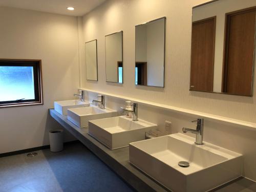a bathroom with three sinks and two mirrors at Kona Stay Bicycle Resort in Izunokuni