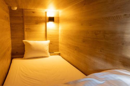 a small room with a bed and a pillow at Kona Stay Bicycle Resort in Izunokuni