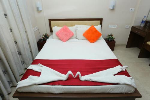 a bed with colorful pillows on it in a room at Hotel Innate Inn in Alwaye