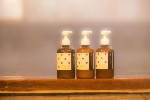 four bottles of honey sitting on a wooden shelf at Kona Stay Bicycle Resort in Izunokuni