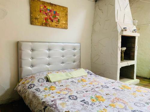 a bedroom with a bed with a quilt on it at Casa artistica CANDELARIA in Bogotá