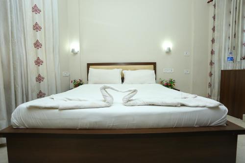a large white bed with white blankets on it at Hotel Innate Inn in Alwaye