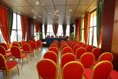 a conference room with red chairs and a table at Hotel Innate Inn in Alwaye