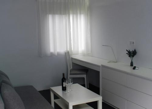 a living room with a desk and a table with a bottle of wine at JINGTU Wellness & Spa B&B in Comares