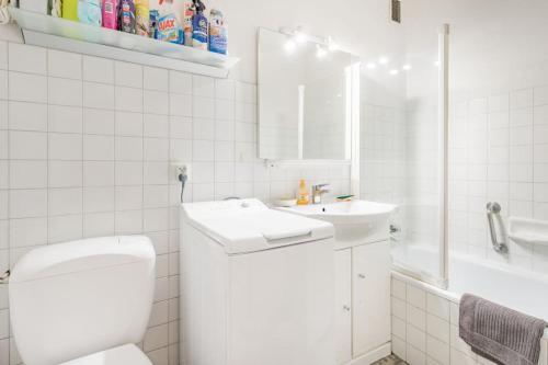 a white bathroom with a toilet and a sink at Royal Center in Brides-les-Bains