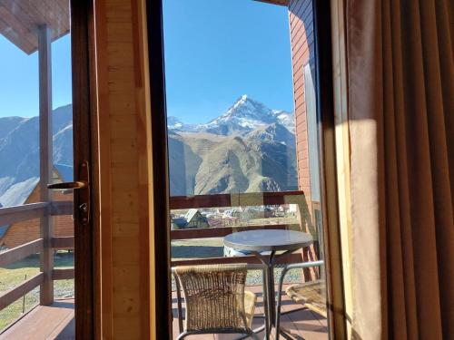 a balcony with a table and a view of a mountain at Kazbegi Twins in Stepantsminda