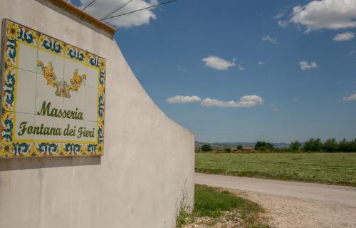 a sign on the side of a wall next to a field at Masseria Fontana dei Fieri in Pietrelcina