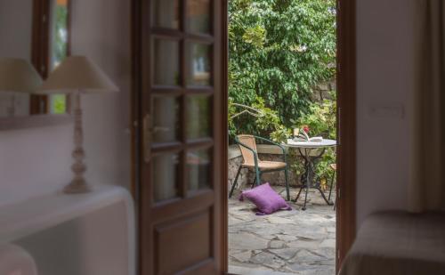 a door leading to a patio with a table and chair at Hotel Sunrise in Fira