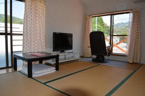 salon z telewizorem z płaskim ekranem i stołem w obiekcie Amakusa - House / Vacation STAY 5321 w mieście Amakusa