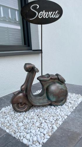 a statue of a scooter sitting on a pile of rocks at Apartment Zielspitz in Parcines