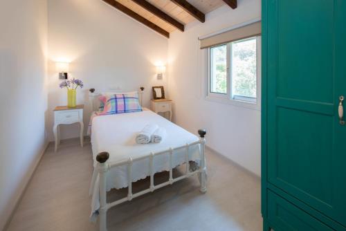 a bedroom with a white bed and a window at Spitaki Pool House & Spitaki Jacuzzi Deluxe Suite in Corfu