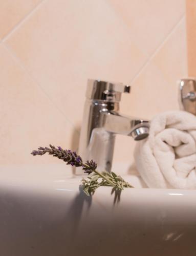 a bathroom sink with a towel and flowers on it at Hotel Sunrise in Fira
