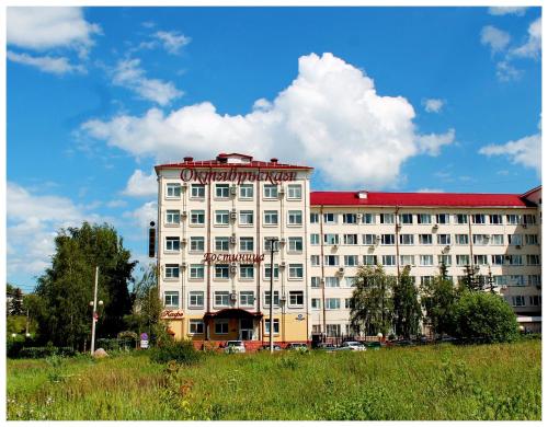 - un grand bâtiment blanc avec un panneau dans l'établissement Oktyabrskaya Hotel, à Tver