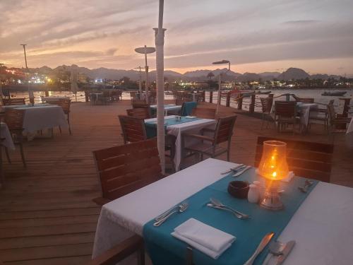 a table with a candle on top of a deck at Marina Sharm Hotel in Sharm El Sheikh